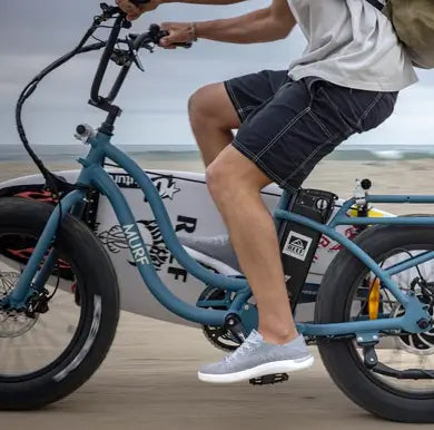 A close up of passenger riding their Higgs step through electric bike to the beach. 